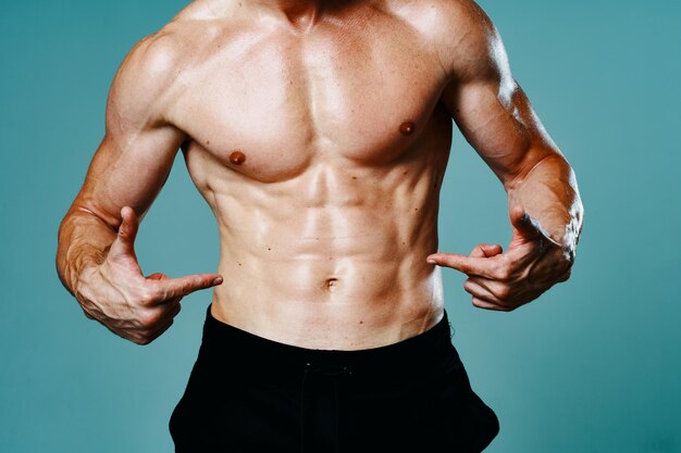 Photo midsection of shirtless man standing against blue background
