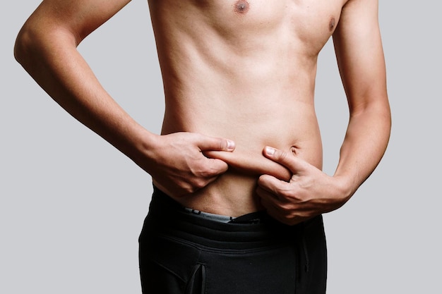 Photo midsection of shirtless man standing against gray background