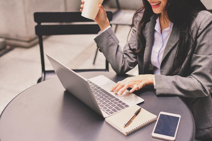 Photo midsection of smiling businesswoman using laptop in cafe