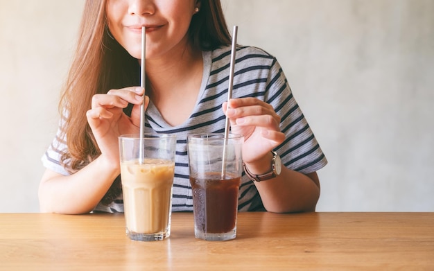 テーブルで飲み物を飲んでいる笑顔の女性のミッドセクション