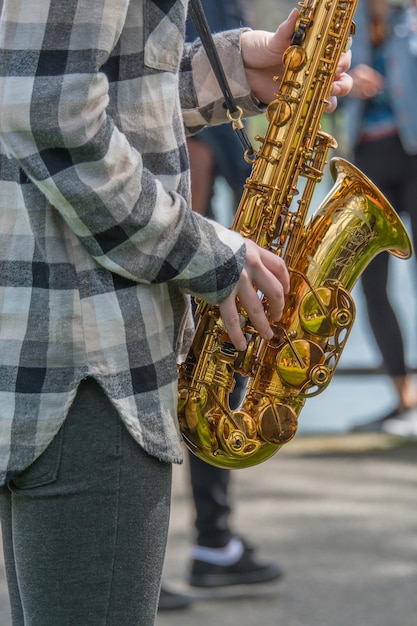 Foto sezione centrale di un musicista di strada che suona il sassofono