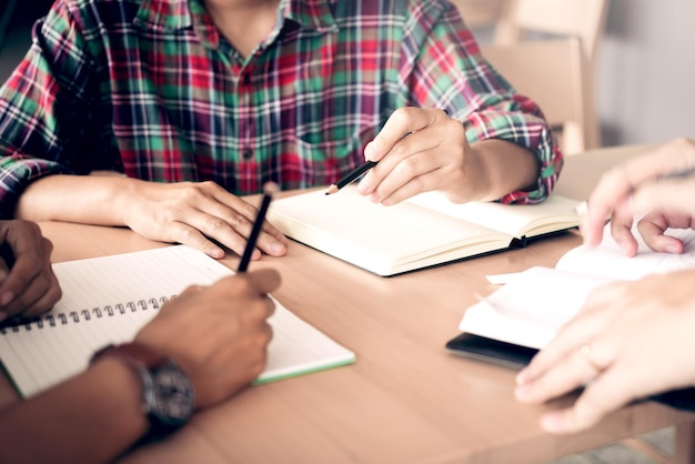 Photo midsection of students studying on desk