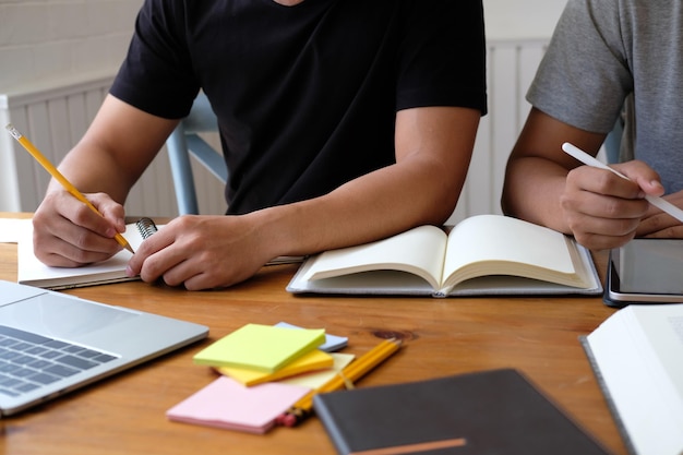 Midsection of students studying on table