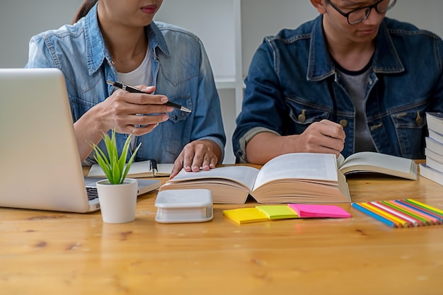 Midsection of students studying on table