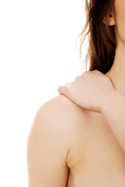 Midsection of topless woman with shoulder pain against white background