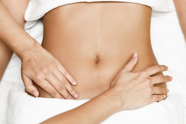 Midsection van therapeut die een vrouw massageert in een schoonheidsspa.