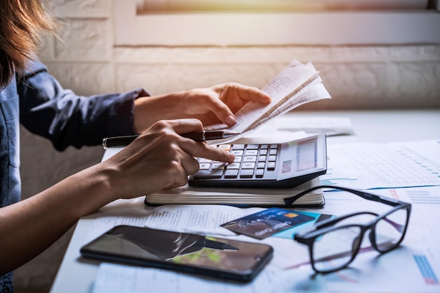 Photo midsection of woman analyzing financial bills on desk