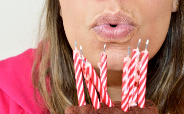 Midsection of woman blowing candles