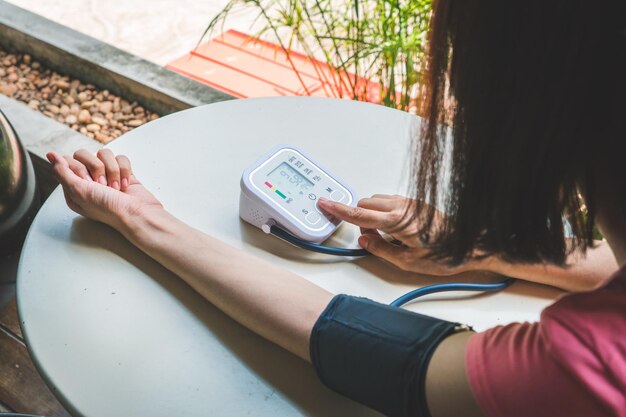 Photo midsection of woman checking blood pressure on table