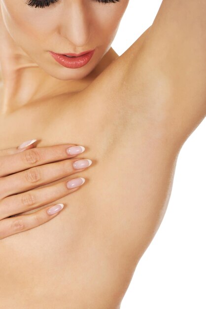 Midsection of woman covering brest against white background