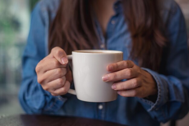 Photo midsection of woman drinking coffee