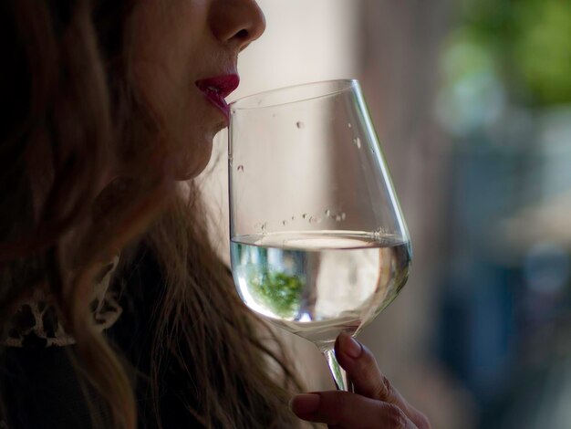 Foto sezione centrale di una donna che beve vino