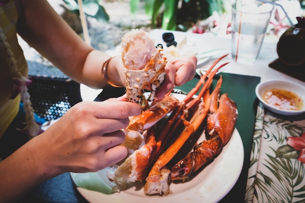 Photo midsection of woman eating crab in restaurant