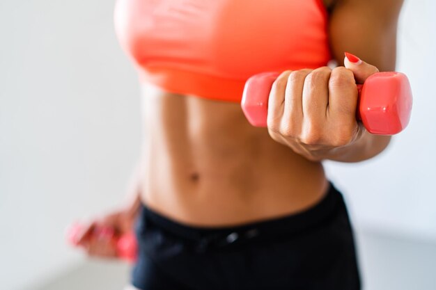 Photo midsection of woman exercising with dumbbells