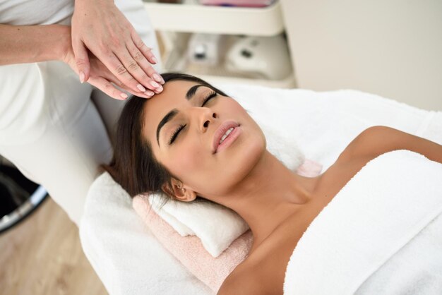 Foto sezione centrale di una donna che dà un massaggio alla testa a un cliente alla spa