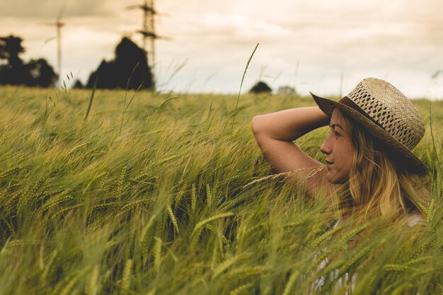 Midsection of woman on grass at field against sky