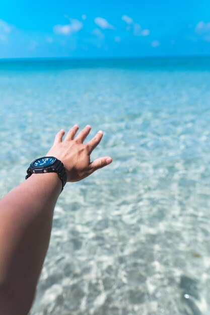 Photo midsection of woman hand by sea against sky