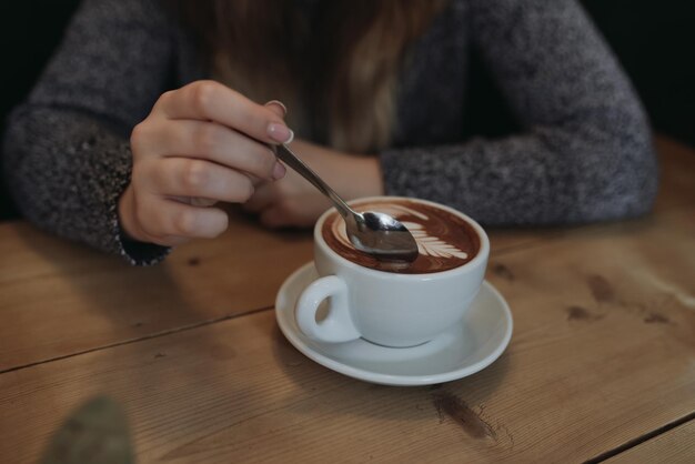 Foto sezione centrale di una donna che beve caffè al tavolo