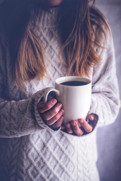 Midsection of woman having coffee