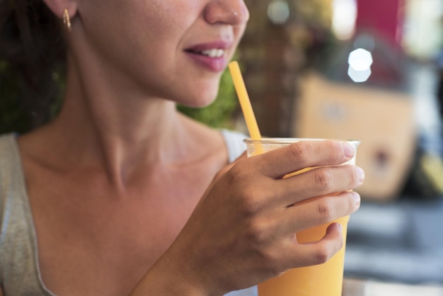 Midsection of woman having drink in glass