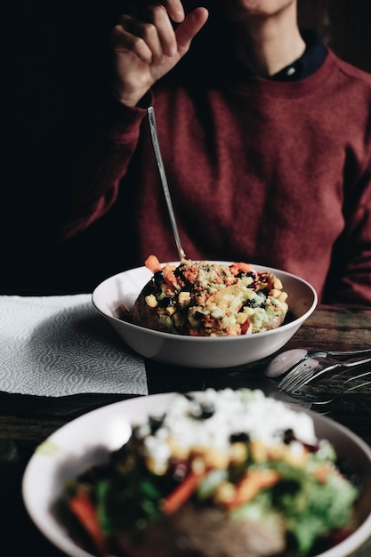 midsection of woman having food in bowl