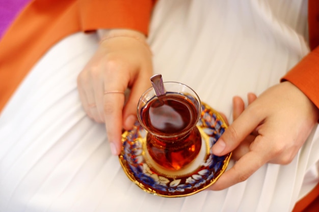 家でハーブティーを飲んでいる女性のミッドセクション