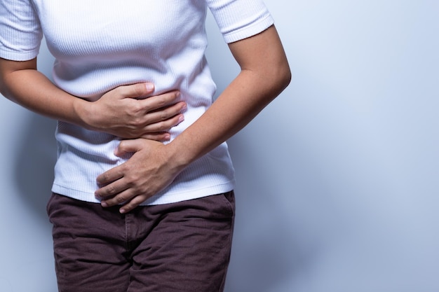 midsection of woman having stomachache against white background