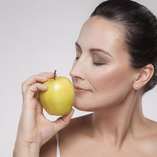 Photo midsection of woman holding apple against white background