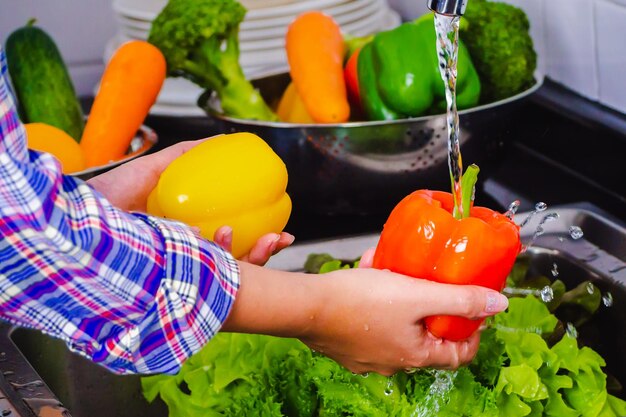 Photo midsection of woman holding bell peppers