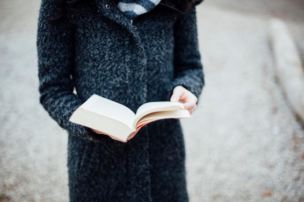 Средняя часть женщины с книгой на поле