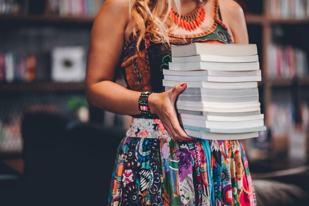 Photo midsection of woman holding book in library