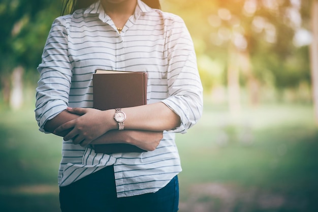 Photo midsection of woman holding book outdoors