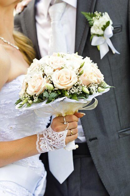 Foto sezione centrale di una donna che tiene un bouquet di rose