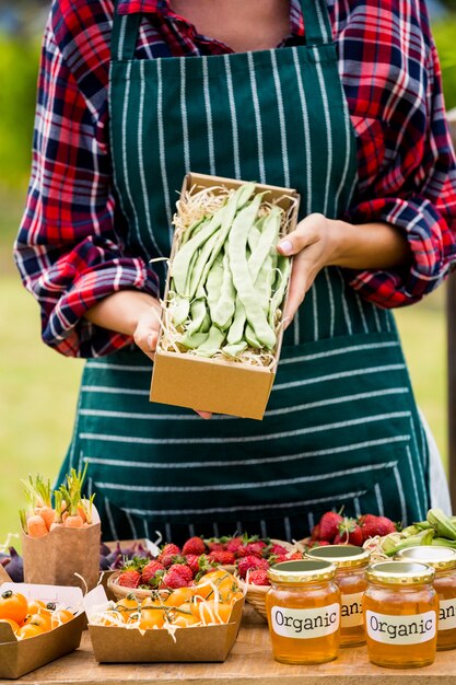 Midsection of woman holding box with vegetables