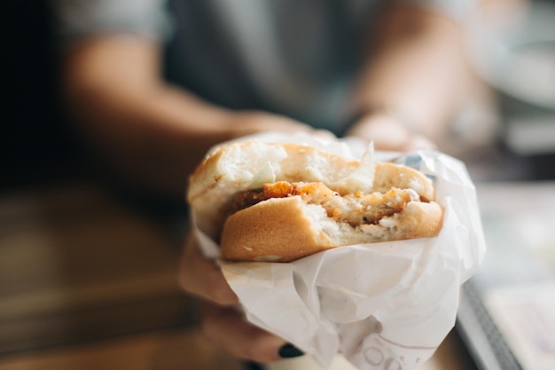 ハンバーガーを握っている女性の中央部分