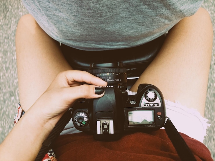 Photo midsection of woman holding camera while sitting on motorcycle with man