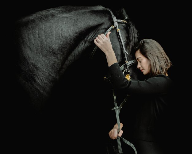 Photo midsection of woman holding camera while standing against black background