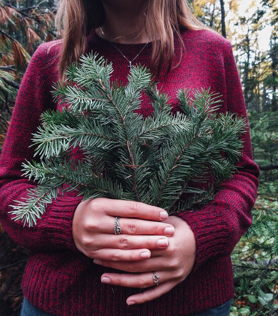 Midsection of woman holding christmas tree