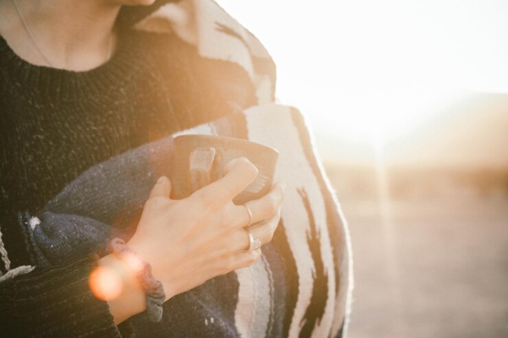Photo 夕暮れの空に向かってコーヒーカップを握っている女性のミッドセクション