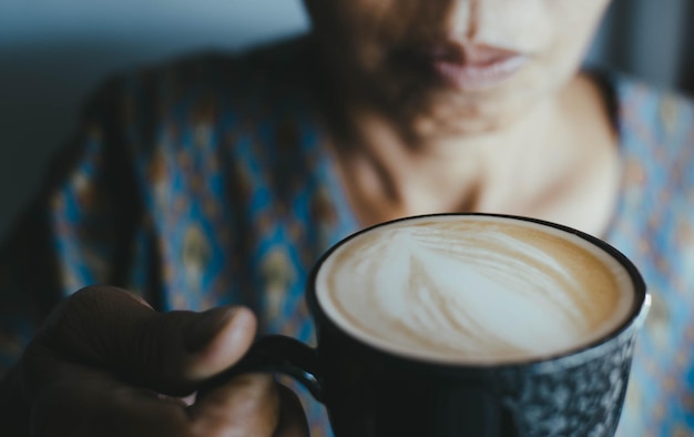 Foto sezione centrale di una donna che tiene una tazza di caffè in un caffè