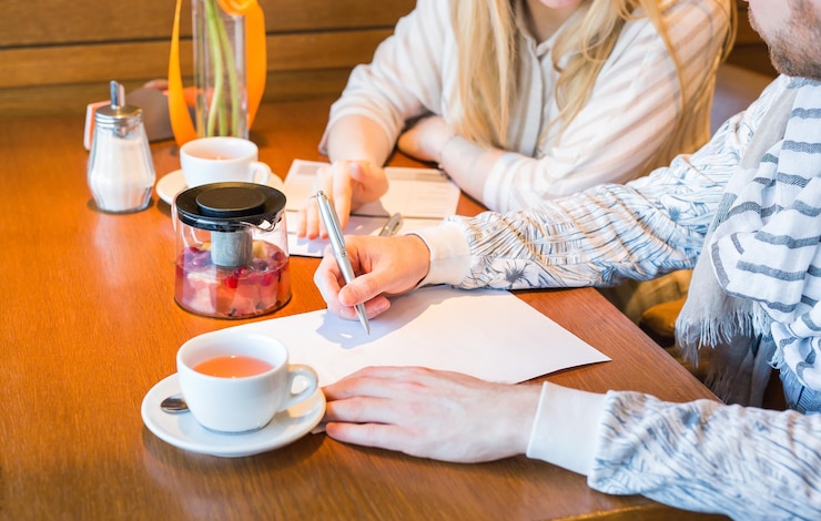Photo テーブルの上にコーヒーカップを握っている女性のミッドセクション