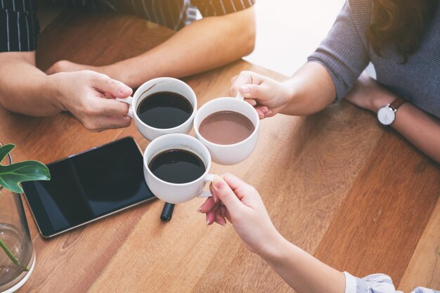 Midsection of woman holding coffee cup on table