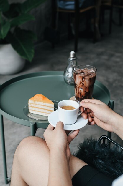 Midsection of woman holding coffee cup on table