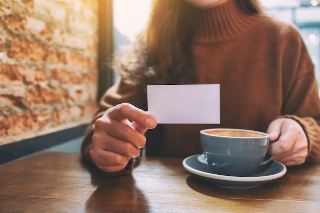 midsection of woman holding coffee cup on table