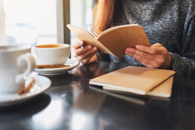 Foto sezione centrale di una donna che tiene una tazza di caffè sul tavolo