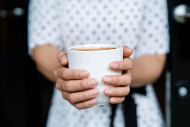 Midsection of woman holding coffee cup