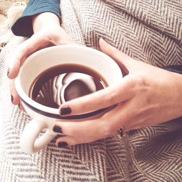 Foto sezione centrale di una donna che tiene una tazza di caffè