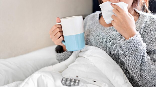 Midsection of woman holding coffee while sitting at home