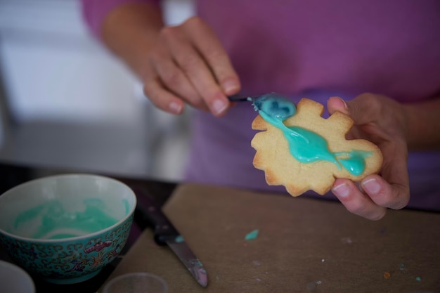 Photo midsection of woman holding cookies on table