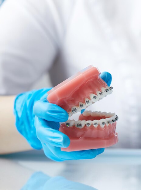Midsection of woman holding dentures